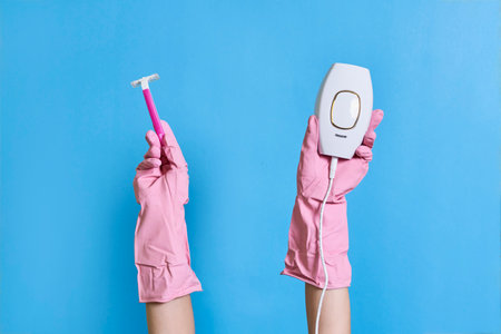 someones hands holding an electric toothbrush in front of their fingers, on a blue background with copy spaceの写真素材