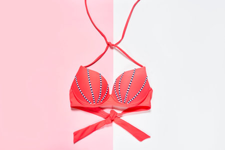 a bikini top on a white and pink background with copy space in the bottom left corner to the right sideの写真素材