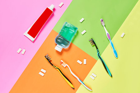 toothbrushs and toothpases on a multi - colored surface with different colors, including pink,...