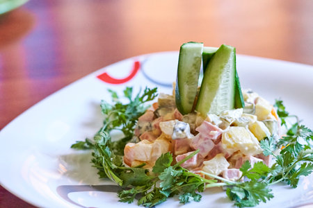 a salad on a white plate with cus and ceints in the center, sitting on a wooden tableの写真素材