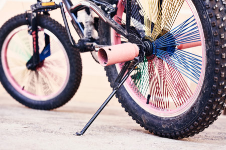 a bike that has been painted pink and blue with black spokes on the front wheel, as if its not in