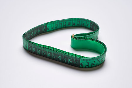 a measuring tape in the shape of a heart on a white background, with copy space for your text stock...