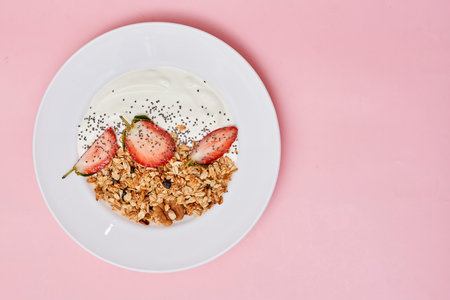 some food on a white plate with strawberries and yories in the background is a pink wall, as wellの写真素材
