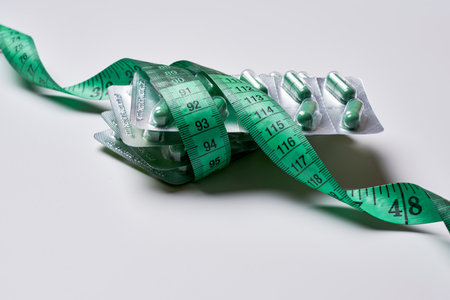 a tape wrapped around a green and white origaal shaped like an elephant, on a light grey backgroundの写真素材