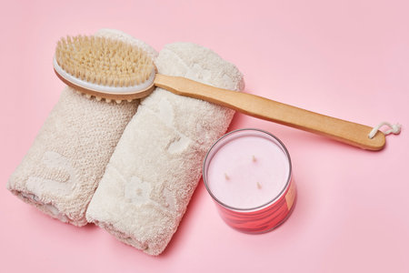 a toothbrush and towel next to a brush on a pink background with an open can of toothpass