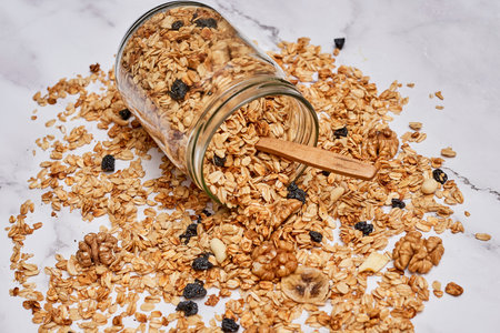 granos in a glass jar on a marble countertopped with blueberries, almonds and blackberriesの写真素材