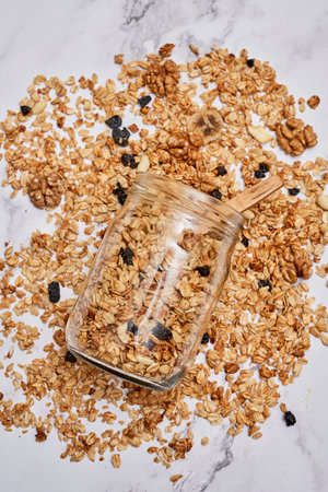 granos in a glass jar on a white marble countertopped with blueberries and almonds scattered aroundの写真素材