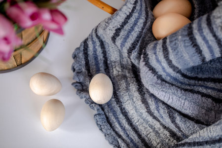 Christ is risen. A basket of eggs stands on a table decorated with flowers.