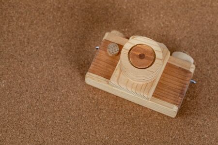Handmade wooden camera lying on a cork tableの写真素材
