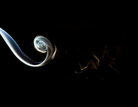 The smoke from the incense sticks on a black backgroundの写真素材