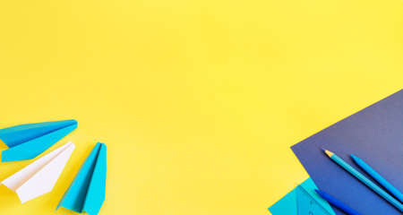 Creative, fashionable, minimalistic, school or office workspace with blue supplies on yellow background. Flat lay.の写真素材
