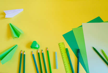 Back to school concept on yellow background with green suppliesの写真素材