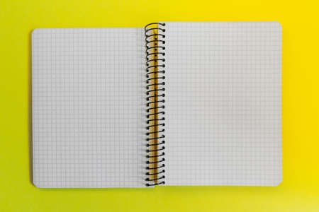 Blank paper spiral notebook on yellow backgroundの写真素材