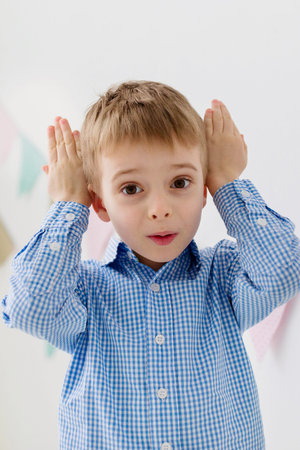 Cute little boy with bunny ears indoors. Easter celebration