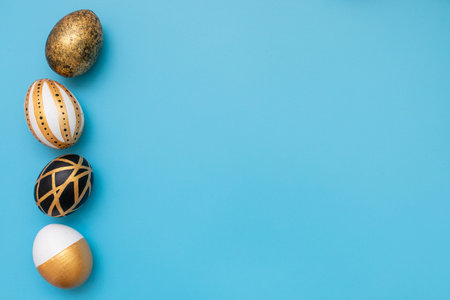 Top view of easter eggs colored with golden and black paint in differen patterns. Minimal easter...