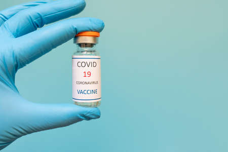 Development and creation of a coronavirus vaccine COVID-19 .Coronavirus Vaccine in glass bottle in hand of doctor blue vaccine jar on white background. Vaccine Concept of fight against coronavirusの写真素材