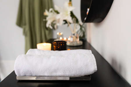 Contemporary interior design in modern house with makeup table, comfort chair, fresh clean towels, natural cosmetic and aroma scene in bathroom. Concept of morning routineの写真素材