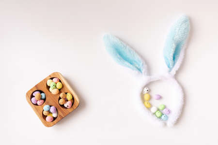Bunny ears and colored little eggs on white background on Easter day. Top view. Symbol Happy Easter holiday concept. Flat lay. Copy space.の写真素材