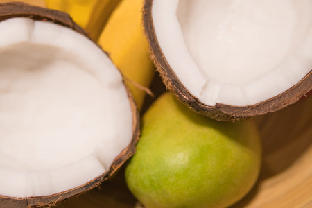 colorful fruit plate made of coconut, bananas and mangoesの写真素材