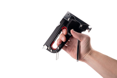 Man's hand holding a black and red stapler isolated on white background