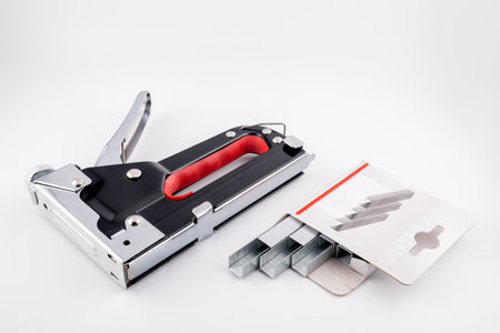 A stapler and staples on a white background with copy spaceの写真素材