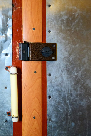 Interior of an old wooden door with a metal frame and a lock