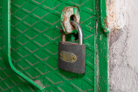 Old padlock on a green door, closeup of photo.の写真素材