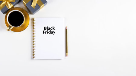 Black Friday text on notepad with coffee and gift box on white backgroundの素材