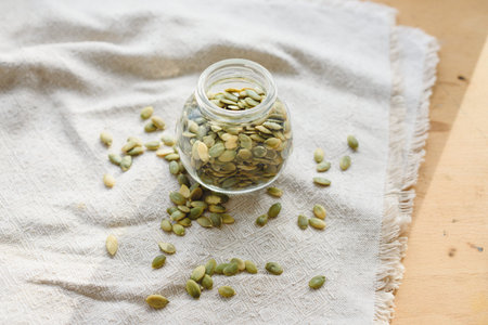 dried pumpkin seeds on linen cloth in a jar of glass