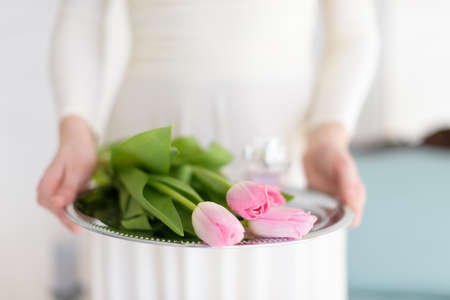 girl holds a tray of flowers bouquet of pink tulipsの写真素材