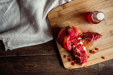 sliced pomegranate on a linen tablecloth, tree, dark backgroundの写真素材