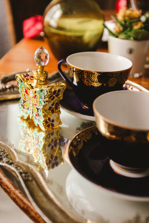 tea couple with a bottle of perfume on a trayの写真素材