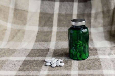 pills and green bank on a brown plaidの写真素材