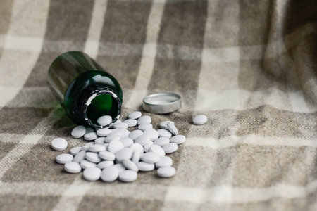 tablets scattered from a bottle on a brown background