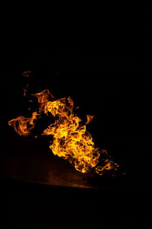 Bright flame in a metal bowl on a black backgroundの写真素材