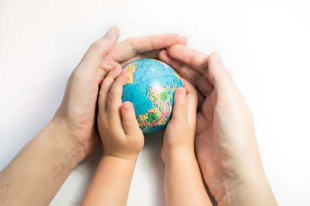 Hands of mother and child holding a globe