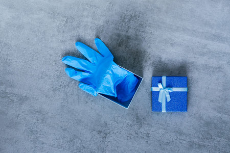 The blue gift box is open. Inside are blue medical gloves. Gift for Valentine's Day, wedding...