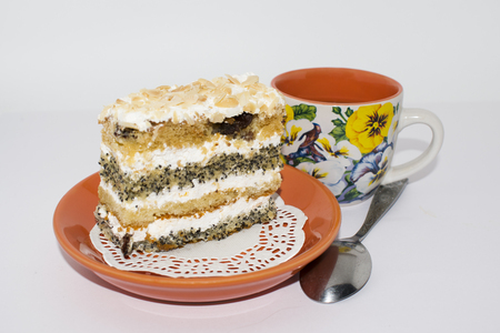 Cake with poppy seeds and almonds on a brown ceramic plateの写真素材