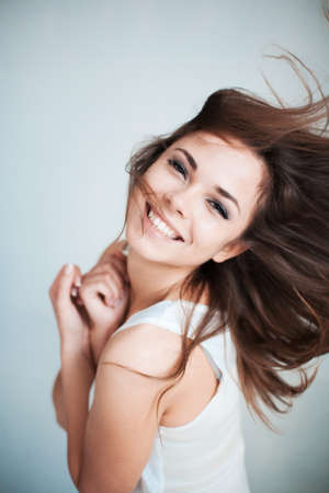 The beautiful young girl happily laughsの写真素材