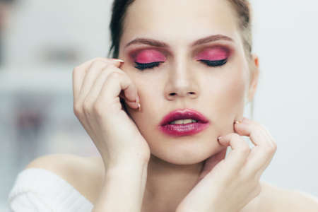 The girl with the smeared lipstick and closed eyes. Studio portrait.の写真素材