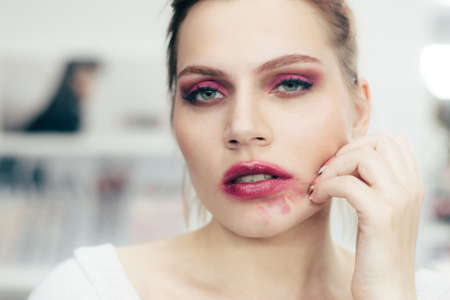 The girl with the smeared lipstick . Studio portrait.の写真素材