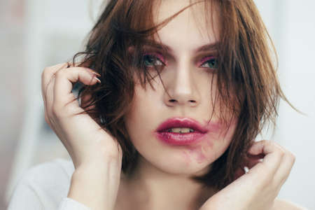 The girl with the smeared lipstick. Studio portrait.の写真素材
