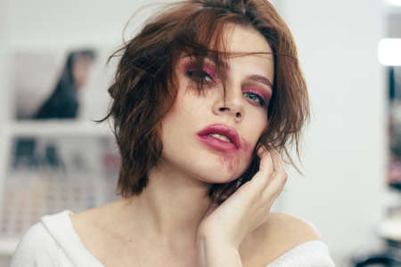 The girl with the smeared lipstick. Studio portrait.の写真素材