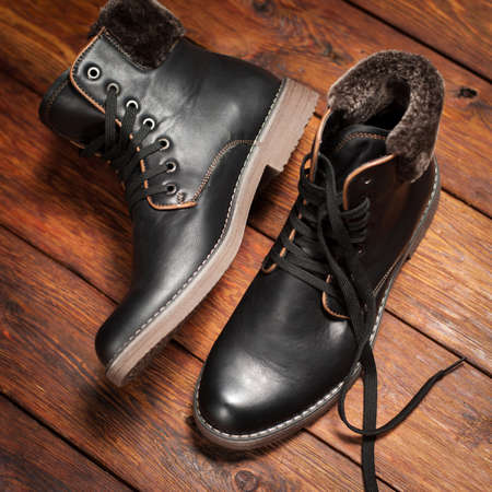 Warm men's leather boots on darkly brown wooden 
backgroundの写真素材