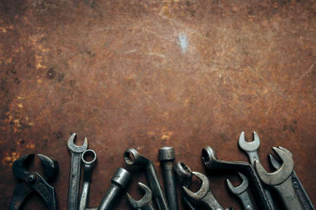 Set of different wrenches on a rusty dark metal backgroundの写真素材