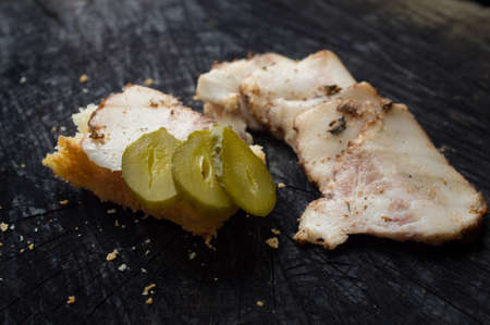 Appetizing slices of becon and sandwich lie on a dark kitchen tableの写真素材