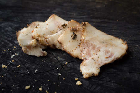 Appetizing slices of salo lie on a dark kitchen tableの写真素材