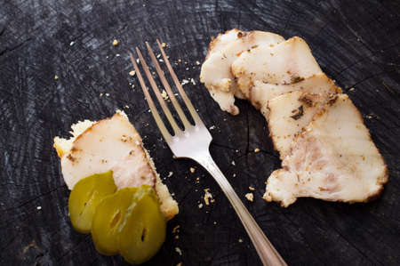Bacon sandwich, fork and salo on a dark kitchen tableの写真素材