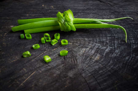 bunch of green onions on the dark backgroundの写真素材