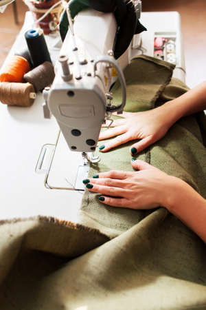 seamstress sews clothes. Workplace of tailor - sewing machine, rolls of of thread, scissors.の写真素材